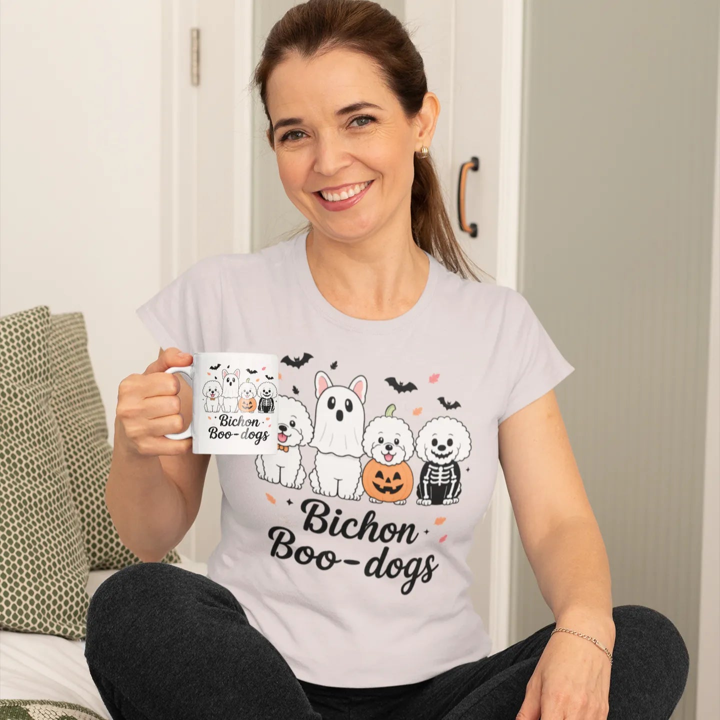 Smiling woman wearing a Bichon Boo-dogs Halloween t-shirt and holding a matching mug, perfect gift for dog lovers