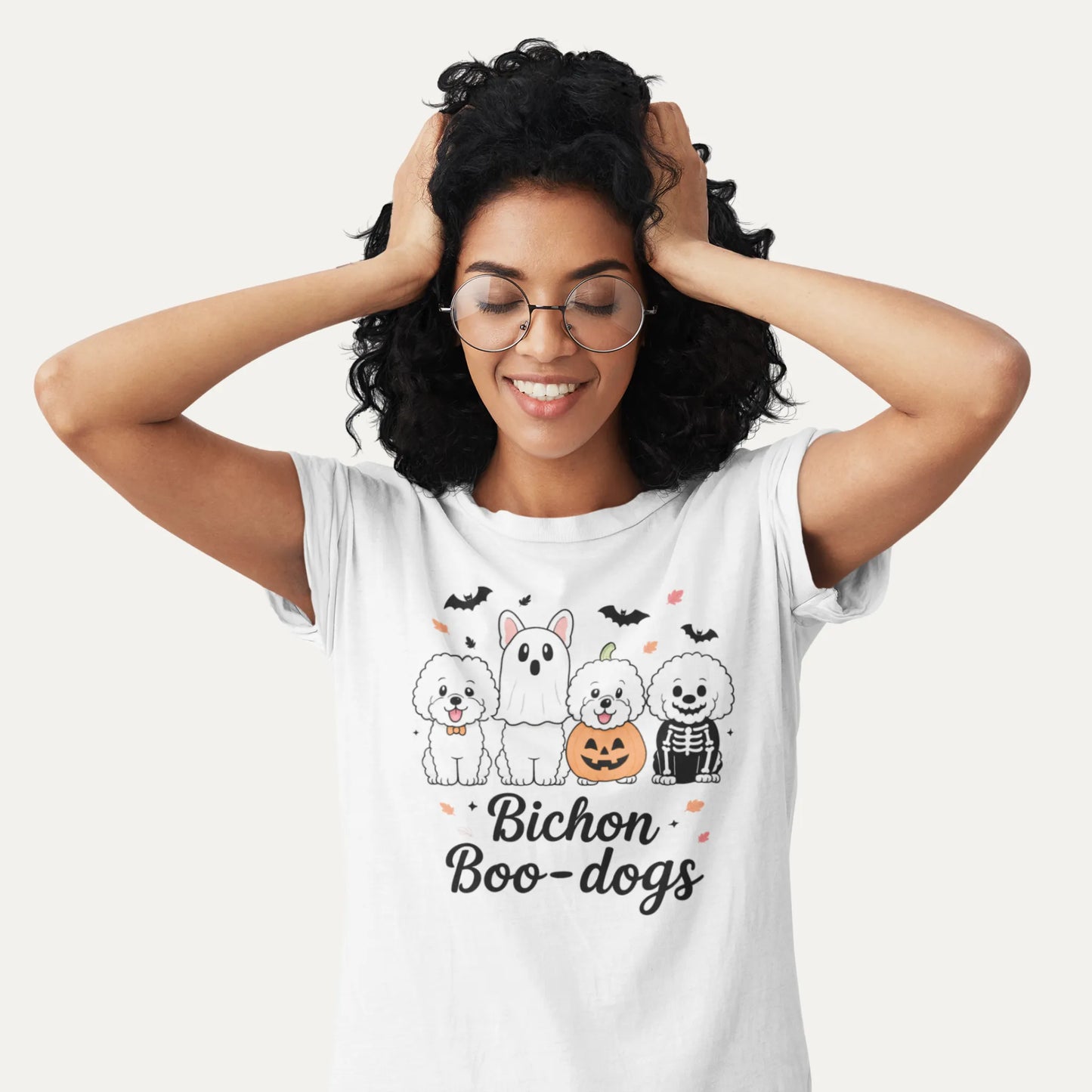 Smiling woman wearing a white Bichon Boo-dogs Halloween shirt with four cute Bichon Frise dogs in spooky costumes