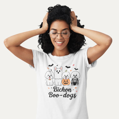 Smiling woman wearing a white Bichon Boo-dogs Halloween shirt with four cute Bichon Frise dogs in spooky costumes