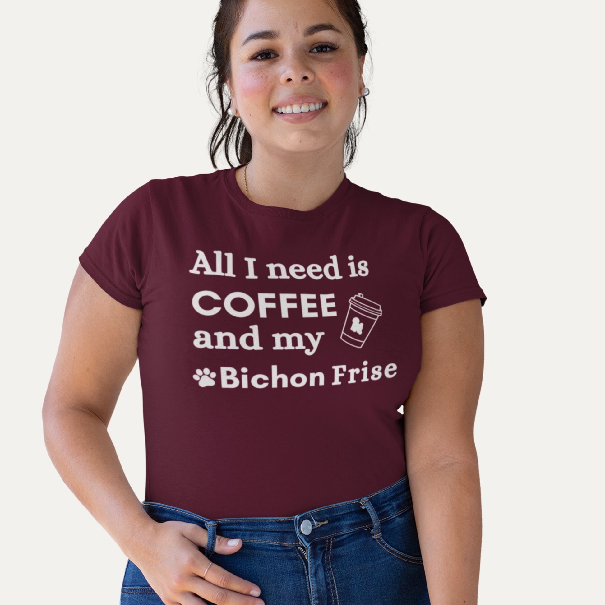 Smiling woman wearing a burgundy T-shirt with 'All I need is coffee and my Bichon Frise' quote – perfect for dog moms and coffee lovers
