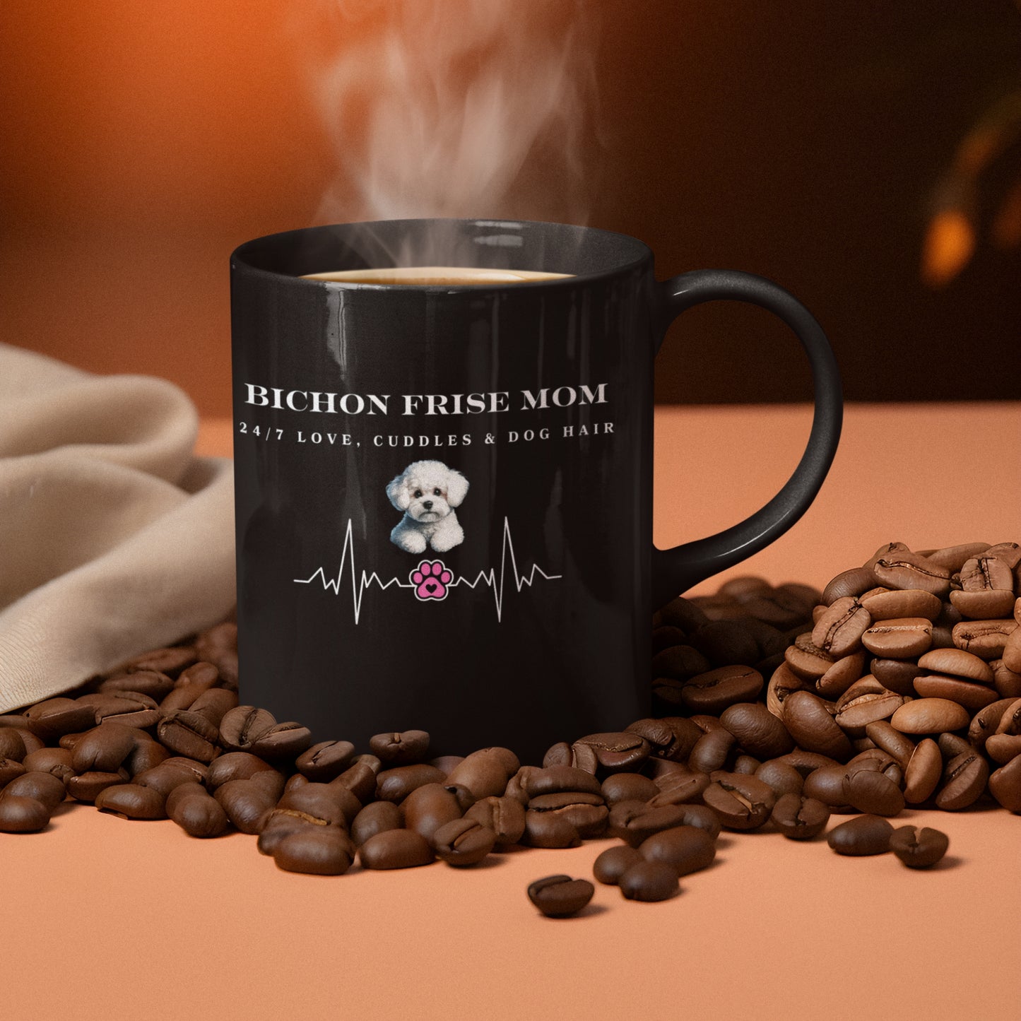 Black ceramic coffee mug with 'Bichon Frise Mom – 24/7 Love, Cuddles & Dog Hair' heartbeat design, surrounded by coffee beans on a warm-toned background.