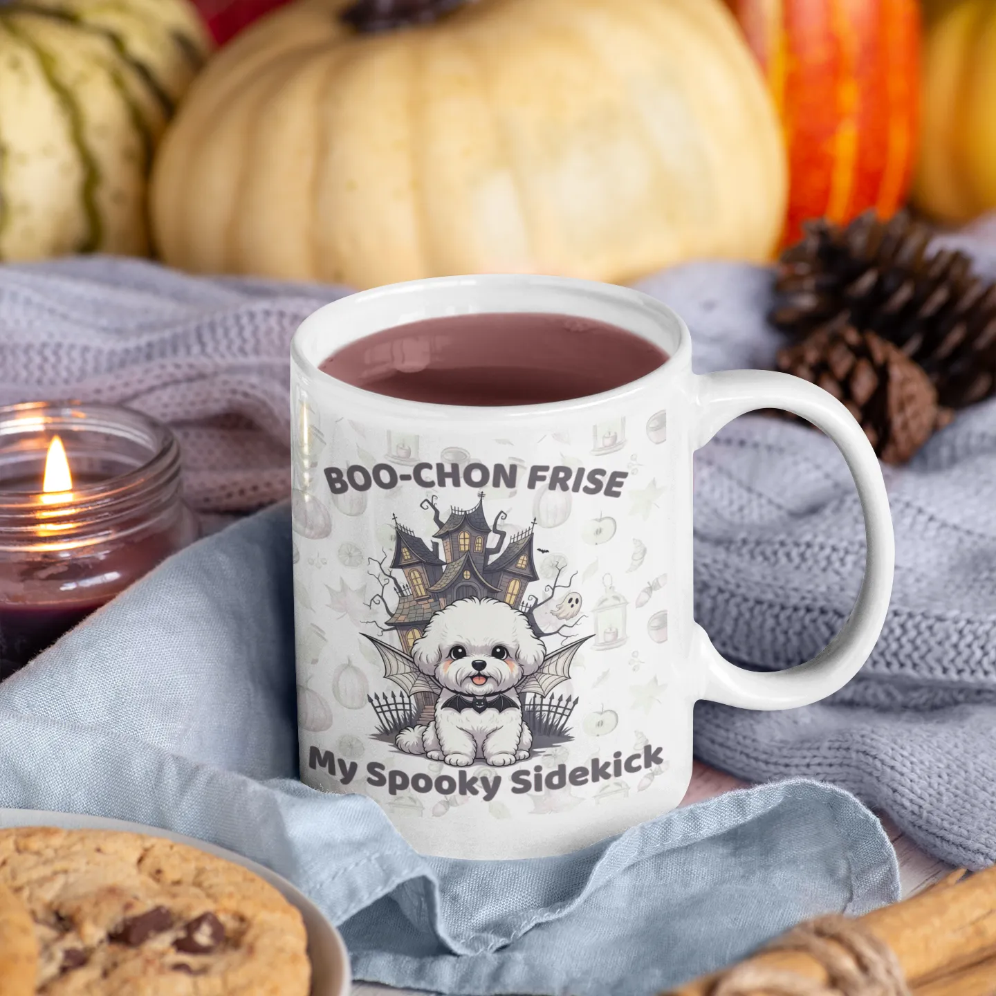 White Halloween mug with Boo-Chon Frise design, surrounded by pumpkins, cookies, and cozy autumn decorations – perfect for spooky dog lovers