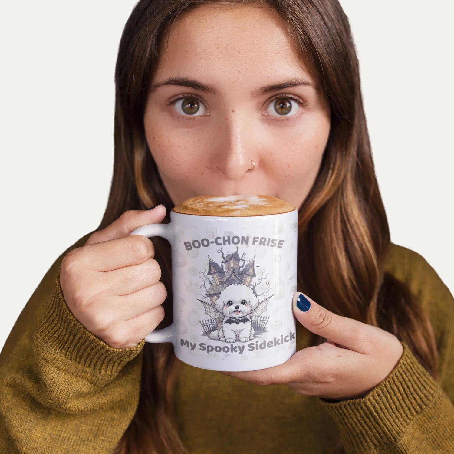 Girl sipping hot chocolate from a white mug featuring a Boo-Chon Frise Halloween design – cozy and spooky mug mockup for dog lovers