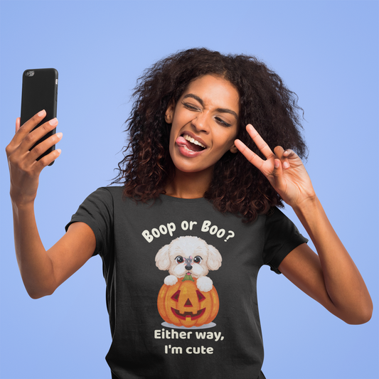 Woman wearing a black Halloween t-shirt with a cute Bichon Frise popping out of a pumpkin and the text “Boop or Boo? Either way, I’m cute” while taking a selfie and making a peace sign – funny dog lover shirt mockup.