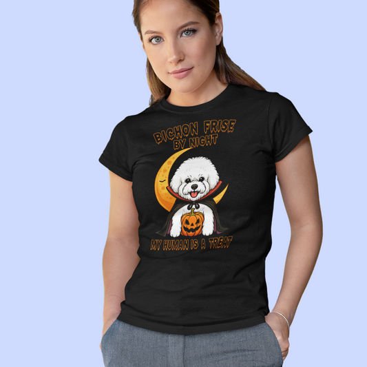 Woman wearing a black T-shirt with a funny Halloween design featuring a Bichon Frise in a vampire costume holding a pumpkin. Text on shirt: “Bichon Frise by Night – My Human is a Treat