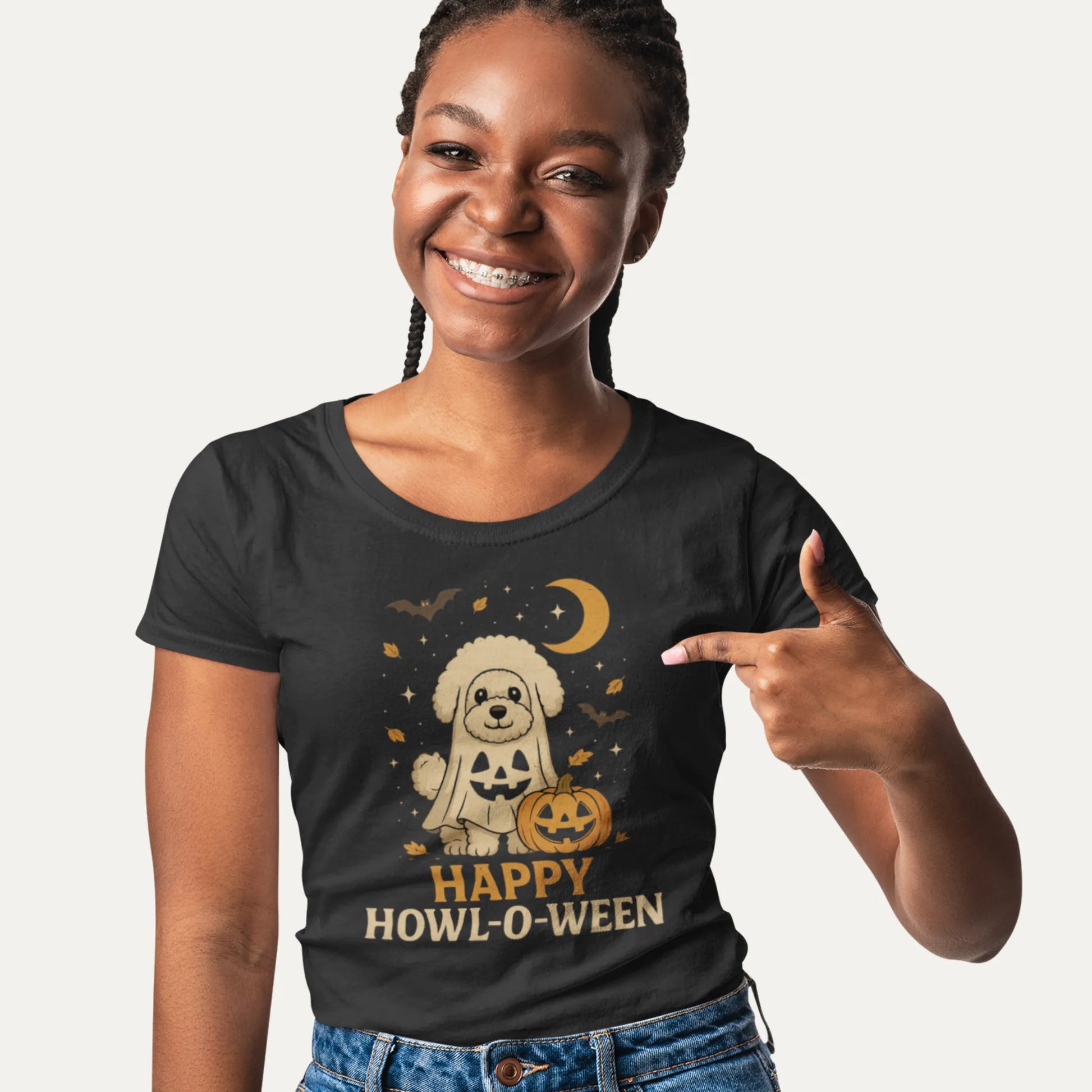 Smiling woman wearing a black t-shirt with a cute Bichon Frise in ghost costume and pumpkin, featuring the text "Happy Howl-o-ween", perfect for dog lovers and Halloween fans.
