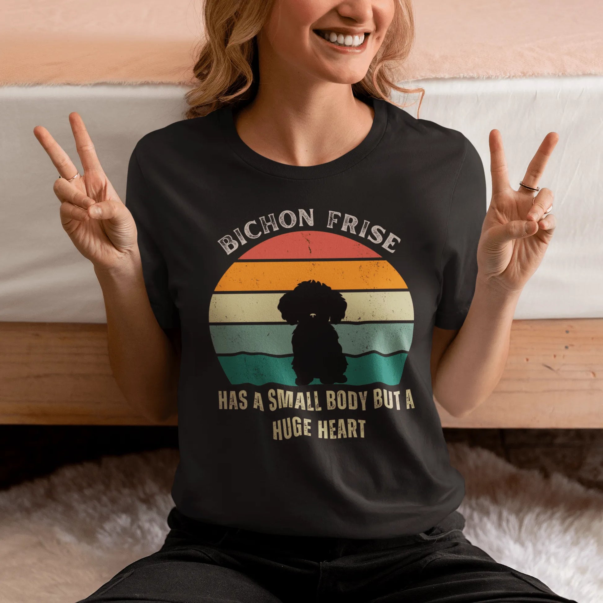 "Colorful unisex T-shirt featuring a cute black dog illustration with the quote 'Has a small body but a huge heart' – perfect for dog lovers, including but not limited to Bichon Frise fans; ideal for both men and women."